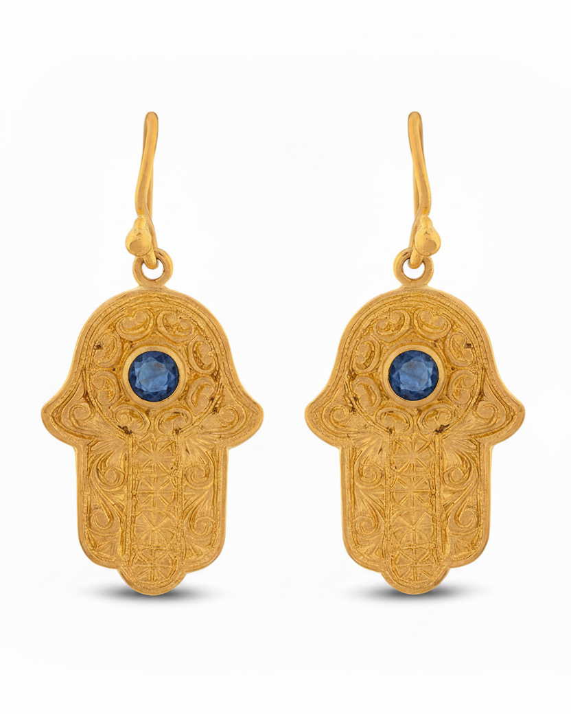 Gold Hamsa hand earrings with blue stones on a white background