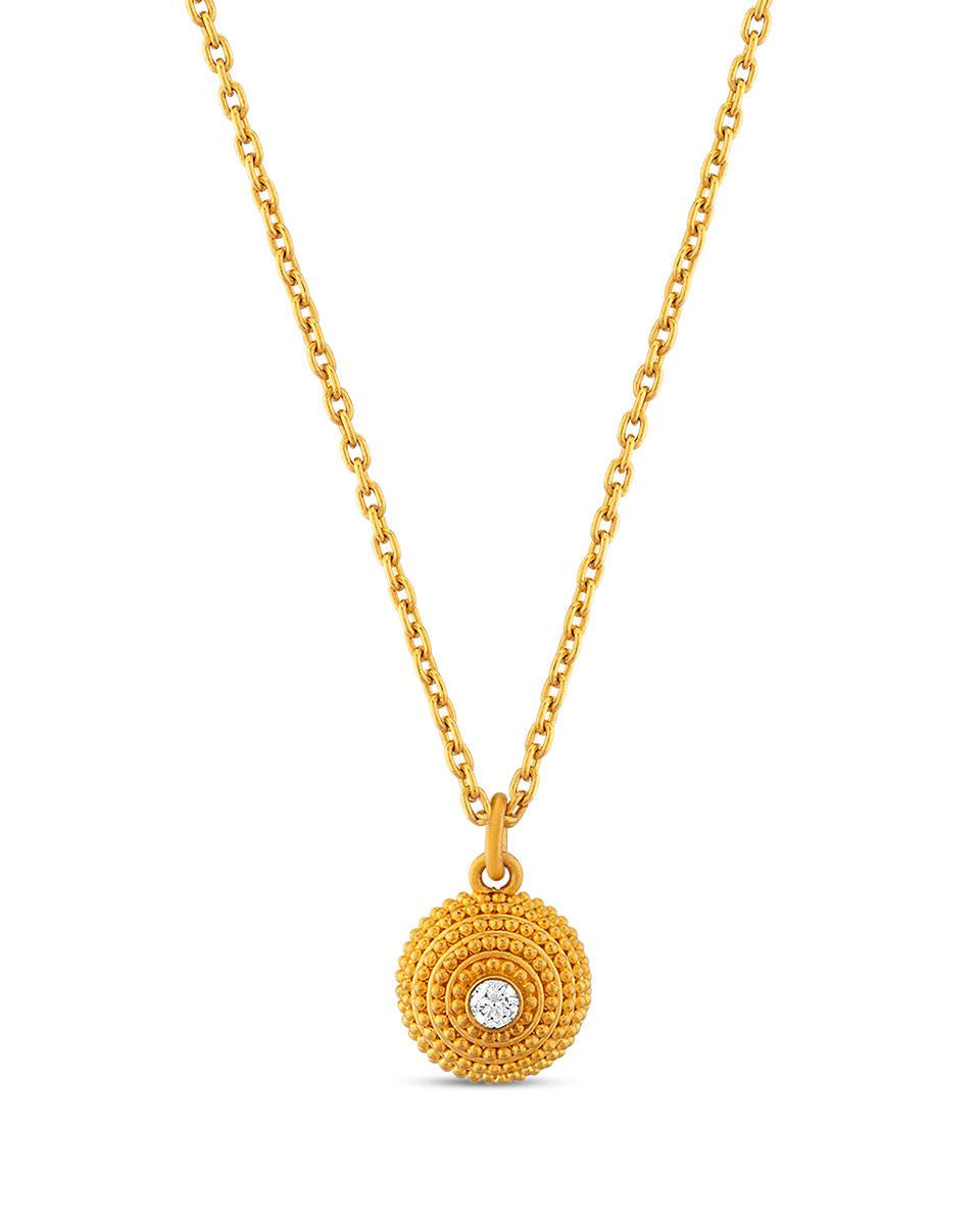 A gold dome pendant with granulated details and a central diamond, against a white background.