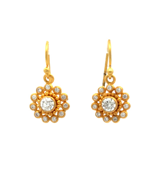 Gold earrings with floral design and clear gemstones on a white background