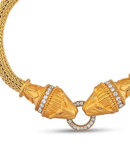 Gold necklace with intricate design and diamond accents on a white background