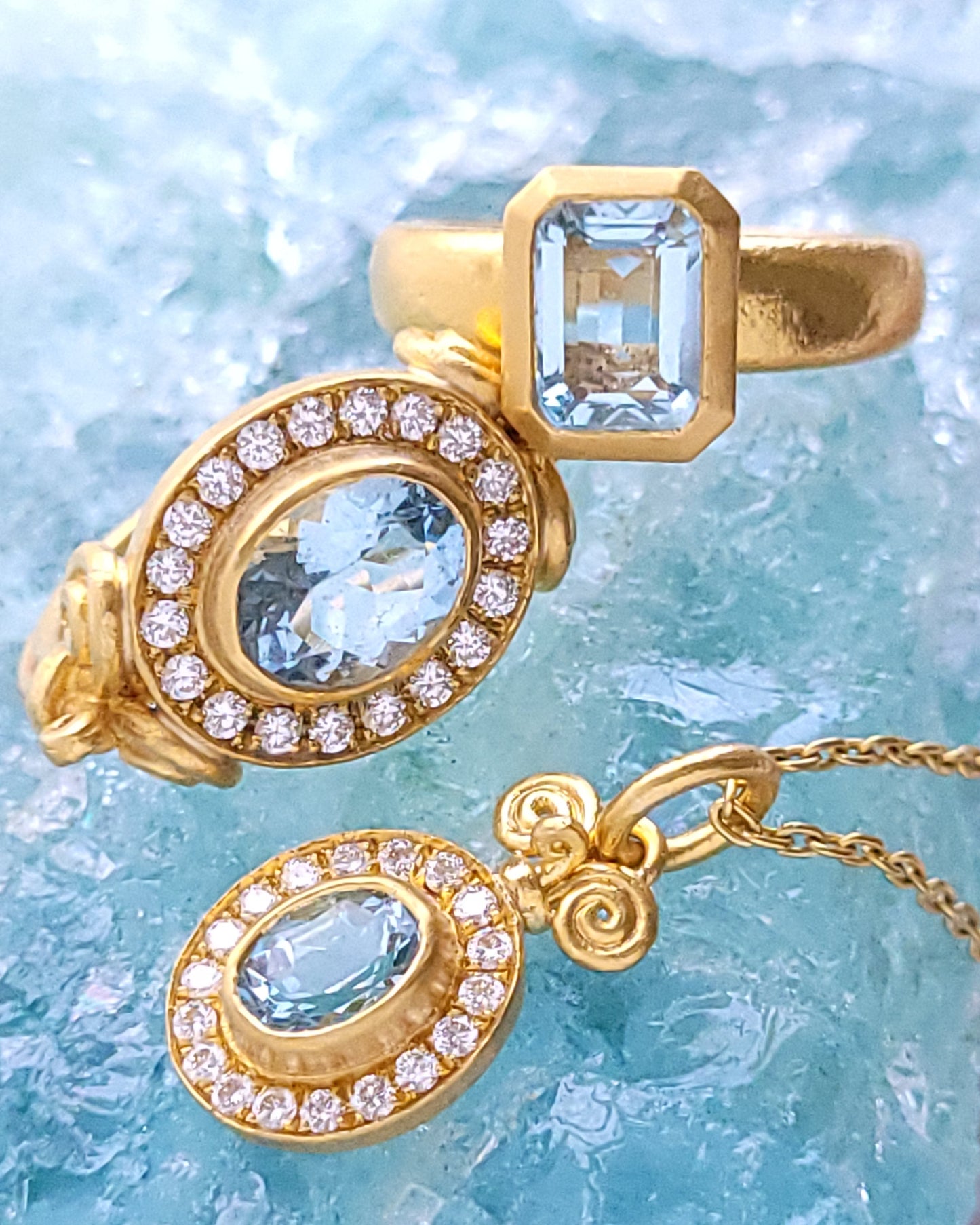 Gold jewelry set with gemstones on a light blue crystal background