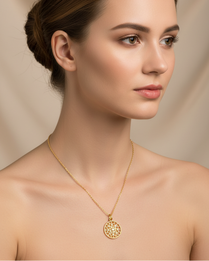 Woman wearing a gold necklace with a circular pendant against a beige background