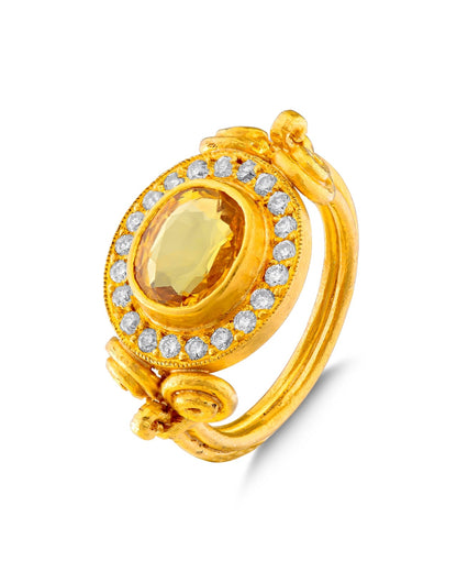 A gold ring with a yellow sapphire in the center and smaller diamond accents.