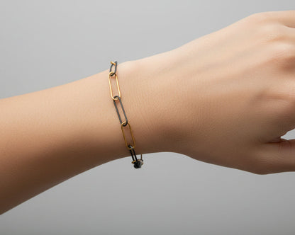 Bracelet with black and gold chain links on a white background