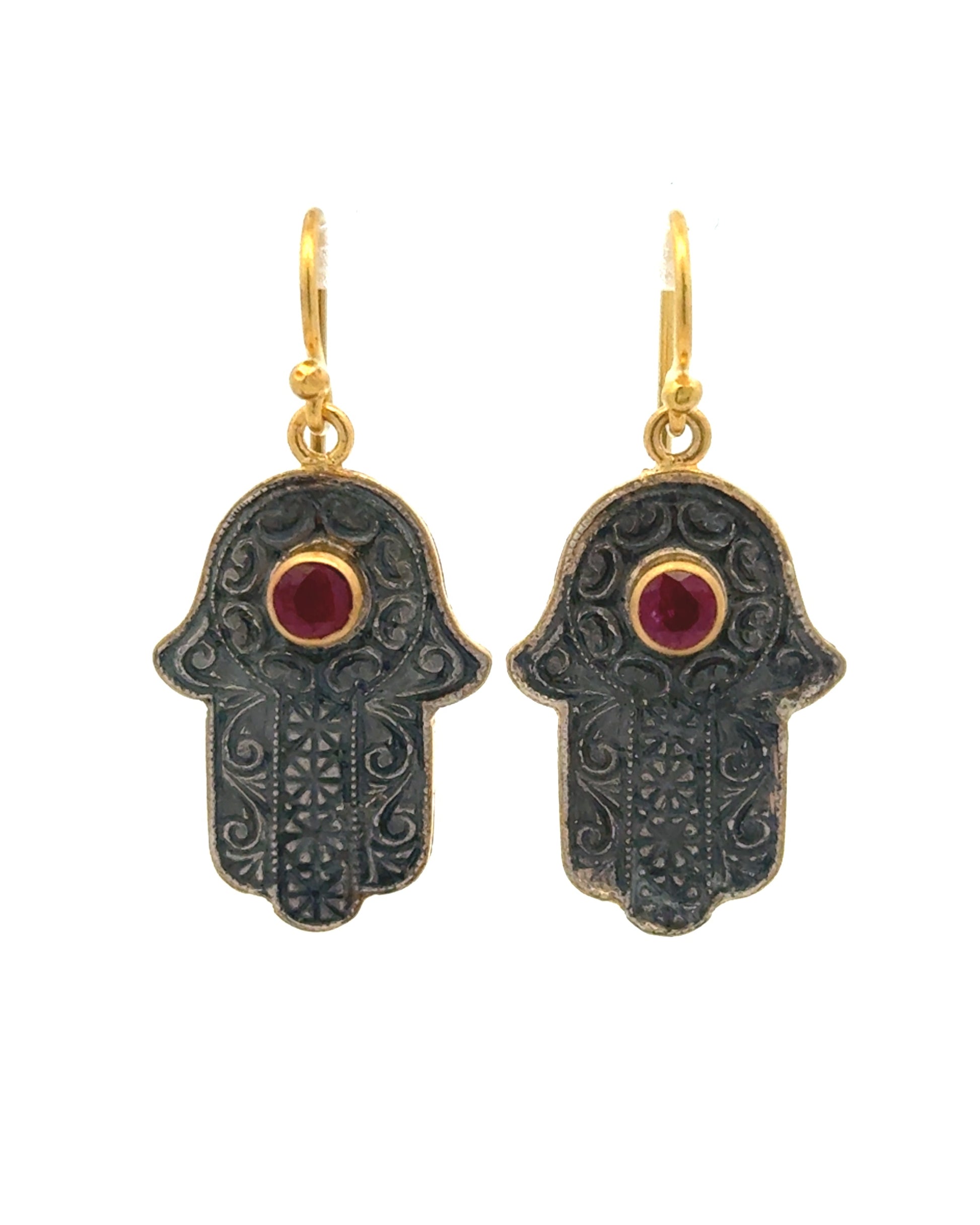 Hamsa hand earrings with gold accents and red gemstones on a white background