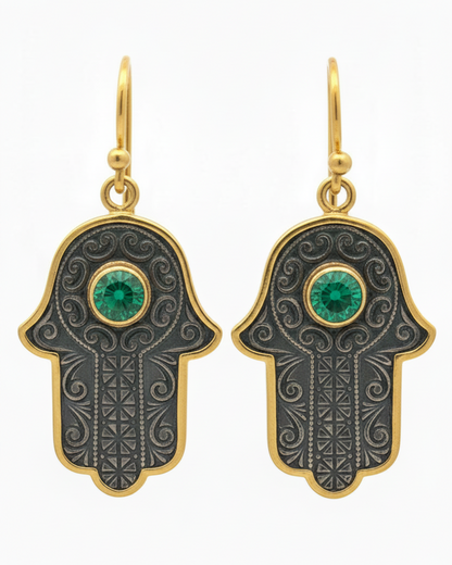 Hamsa hand earrings with green gemstones on a white background