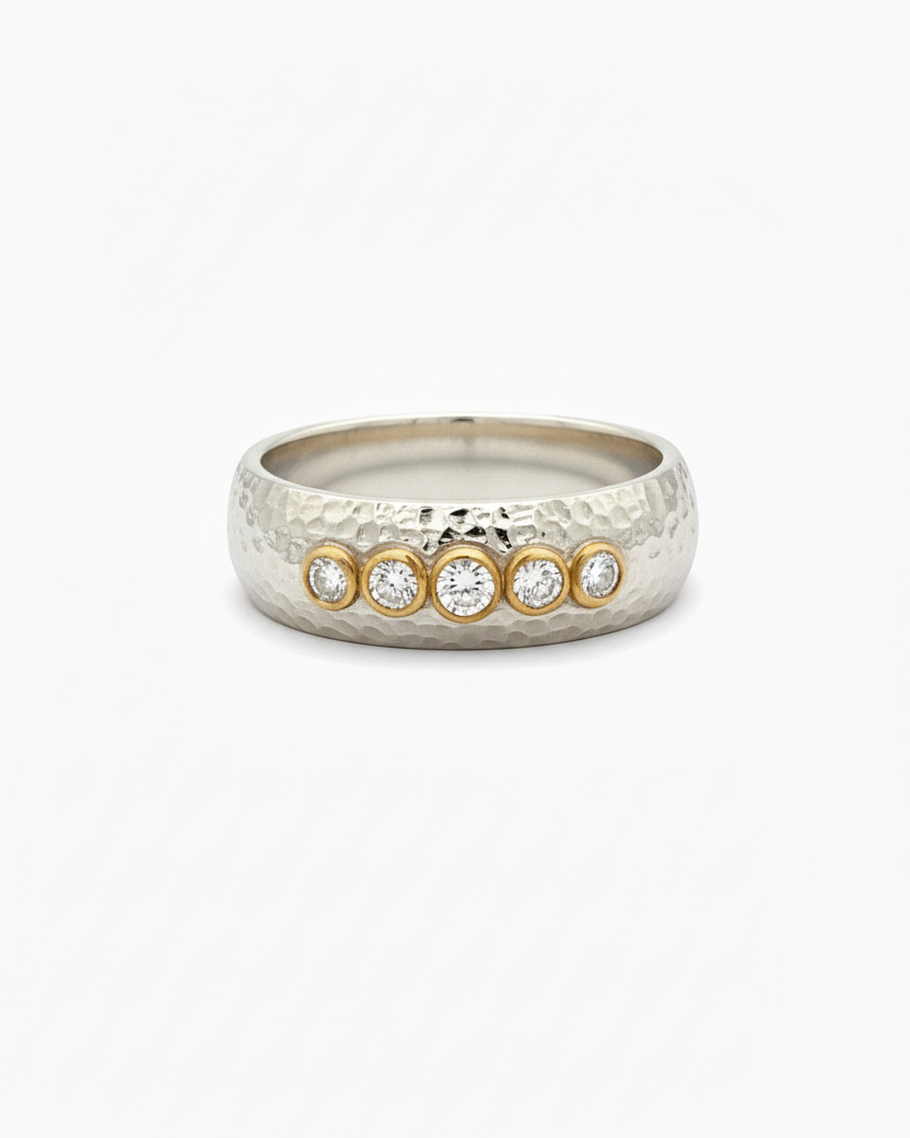 Silver ring with gold accents on a white background