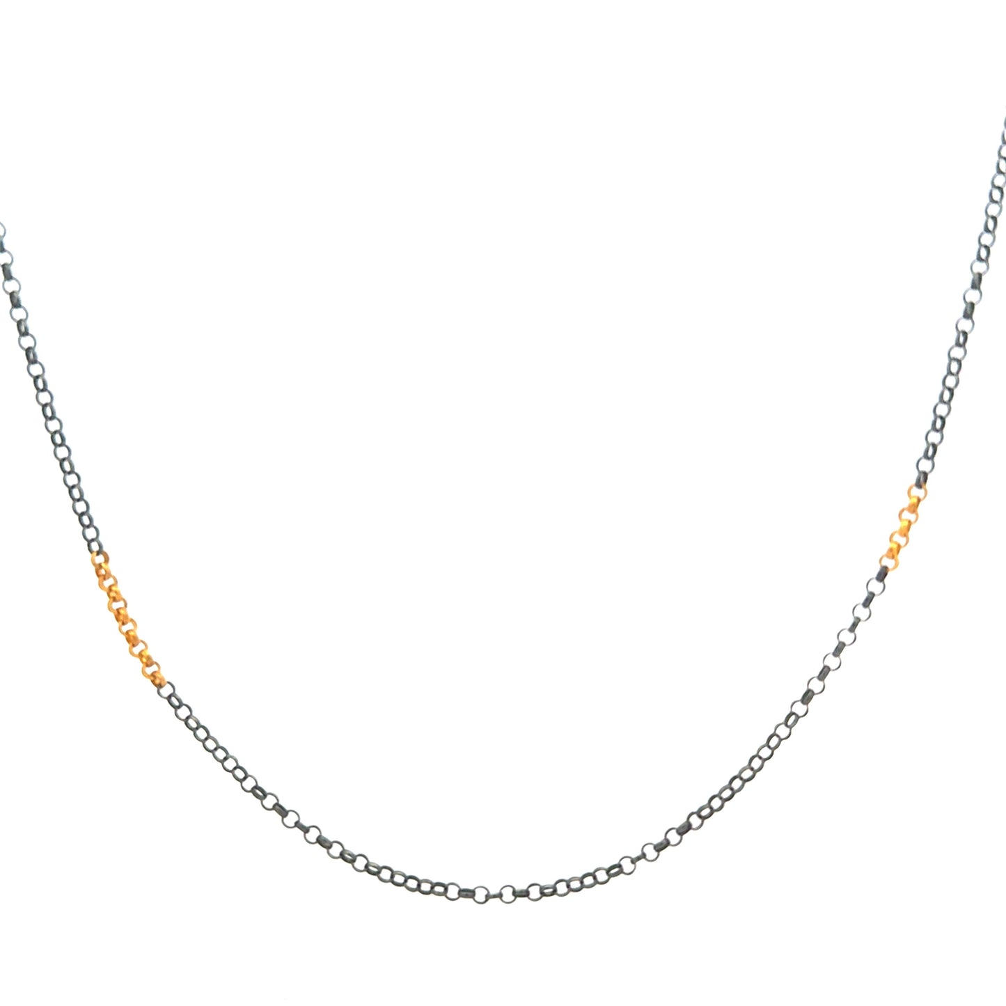 Rolo chain necklace in silver and 24 karat gold on a white background.