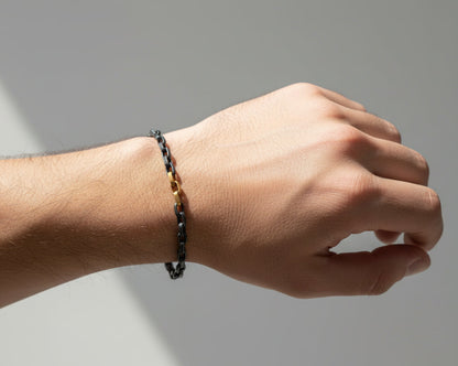 Bracelet with alternating gold and silver chain links on a white background